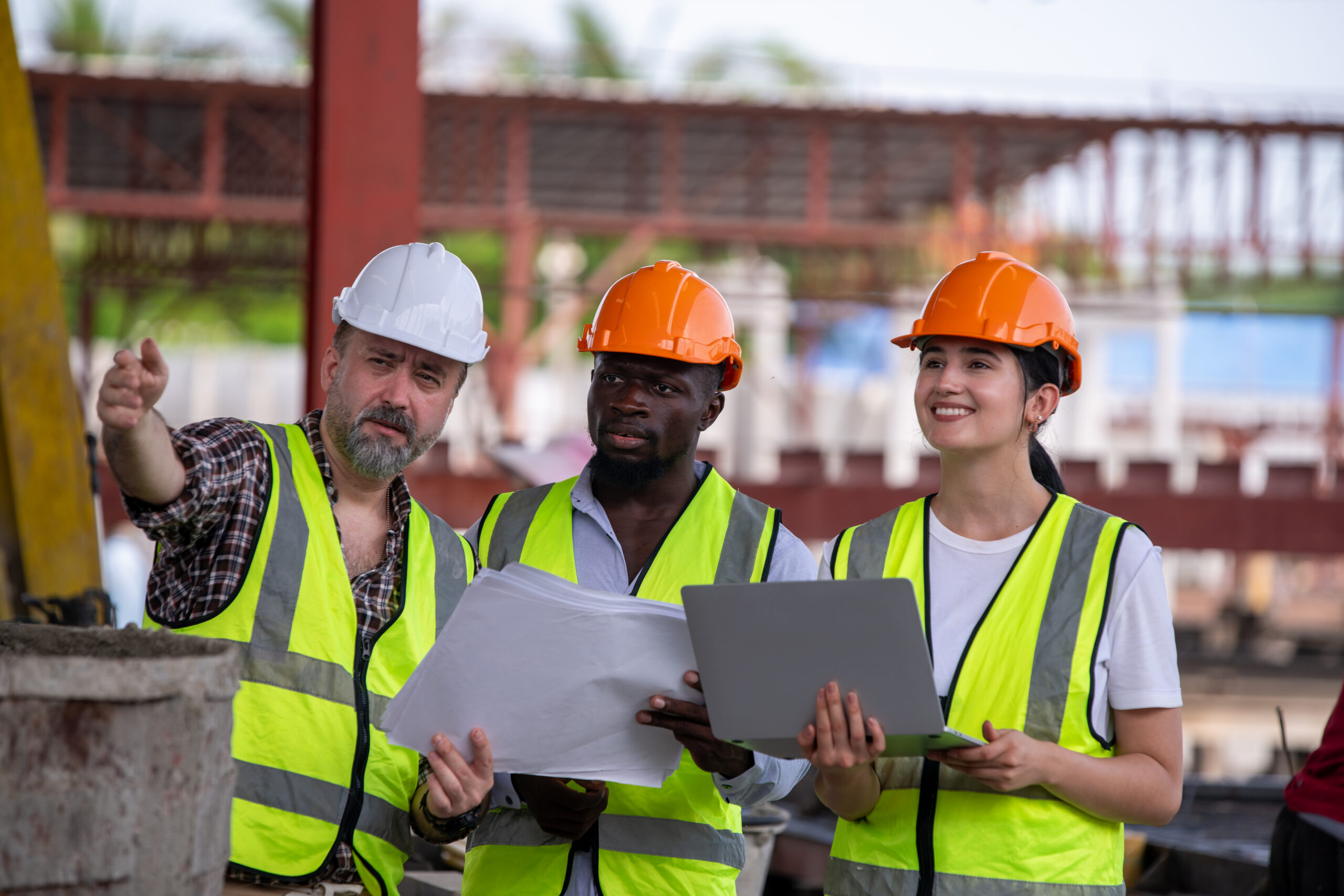 Engineers wearing helmets and vests at construction sit analyzing building plans work environment safety, accuracy and teamwork ensure successful project development.